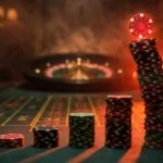 Escalating casino chip stacks on roulette table showing the dangerous exponential growth of Martingale betting system