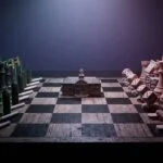 Chess board with tobacco industry pieces facing gambling industry pieces with a school building in the center — representing the parallel between Big Tobacco and DraftKings targeting youth through education programs