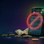 Smartphone displaying betting app with red prohibition sign, Brazilian currency coins, and football representing proposed online gambling ban